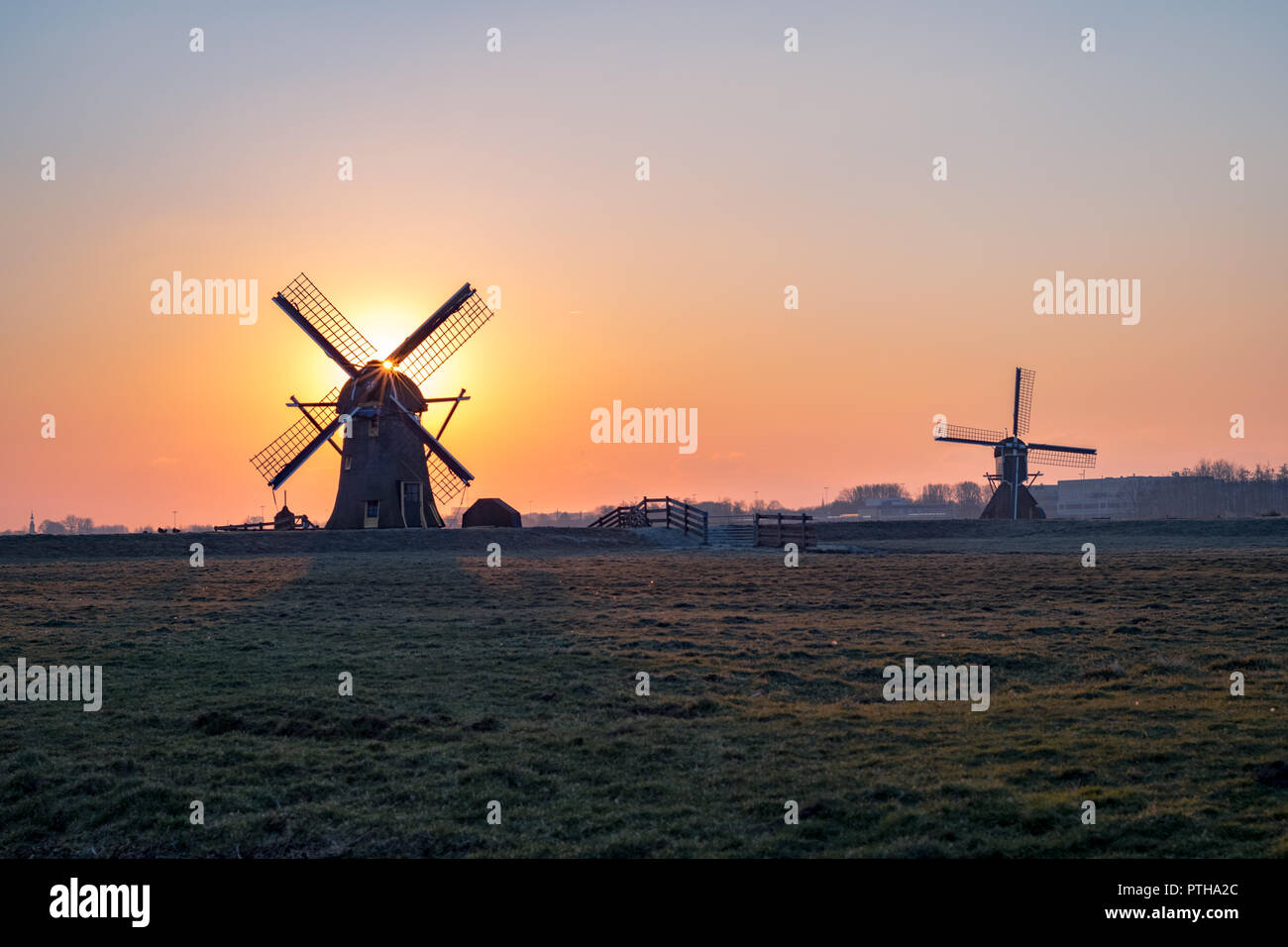 Deux moulins à vent hollandais au coucher du soleil Banque D'Images