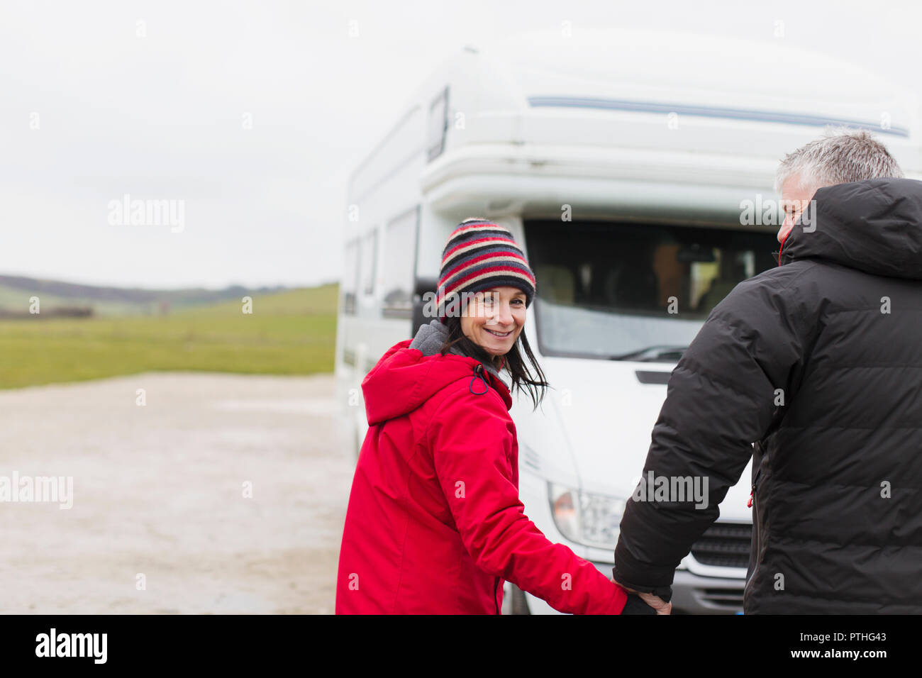 Portrait of smiling couple dans des vêtements chauds à l'extérieur tenant la main motor home Banque D'Images
