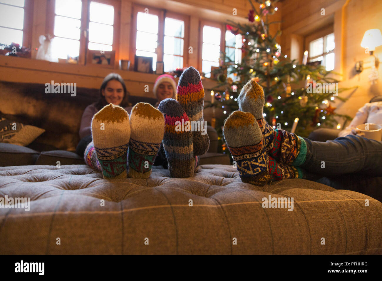 Famille avec chaussettes colorées de vous détendre dans un salon de Noël Banque D'Images