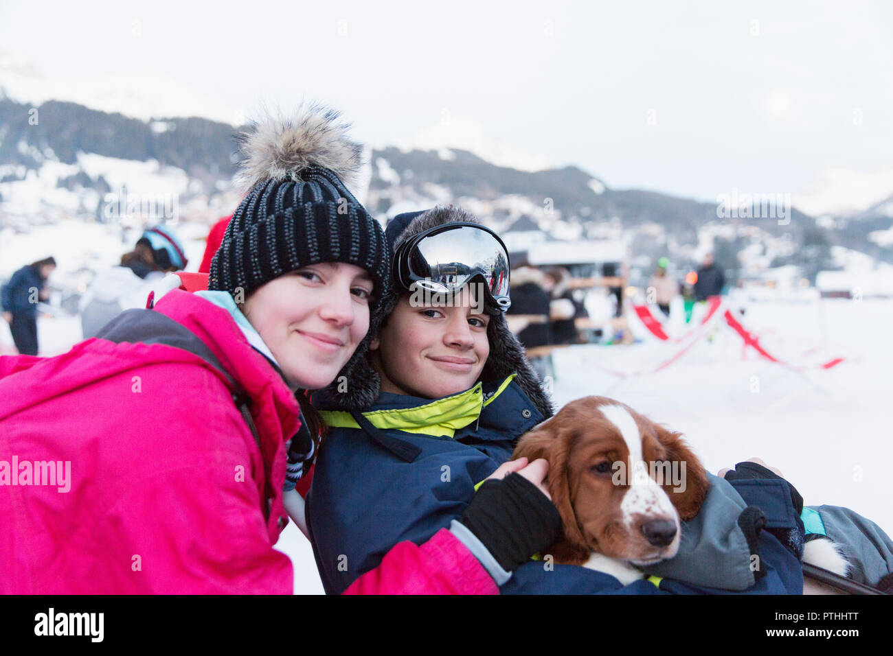 Portrait frère et sœur avec chien sur une piste de ski Banque D'Images