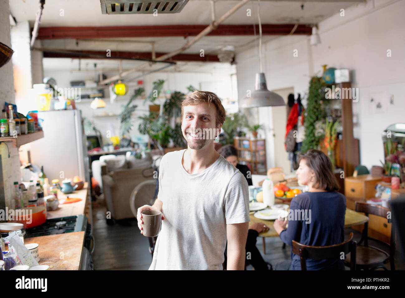 Portrait of smiling man drinking coffee in Cuisine de l'appartement Banque D'Images