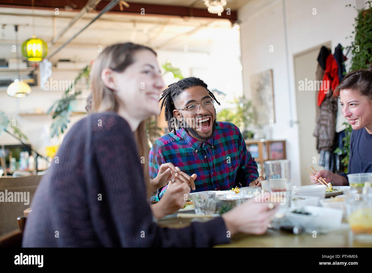 Heureux les jeunes adultes colocataires eating take out food at table de cuisine dans l'appartement Banque D'Images