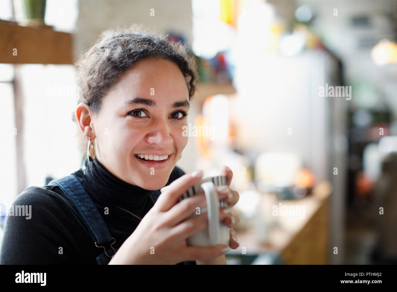 Portrait of smiling young woman drinking coffee Banque D'Images