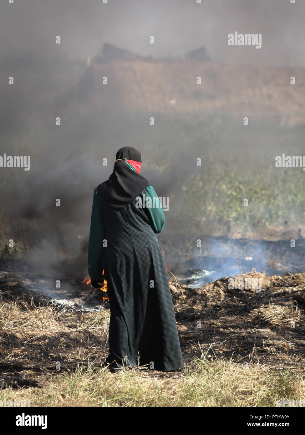 Une fille palestinienne en face de soldats israéliens sur la frontière Israel-Gaza lors d'une protestation de la ville de tentes pour obtenir le droit de retourner dans leur patrie. Banque D'Images