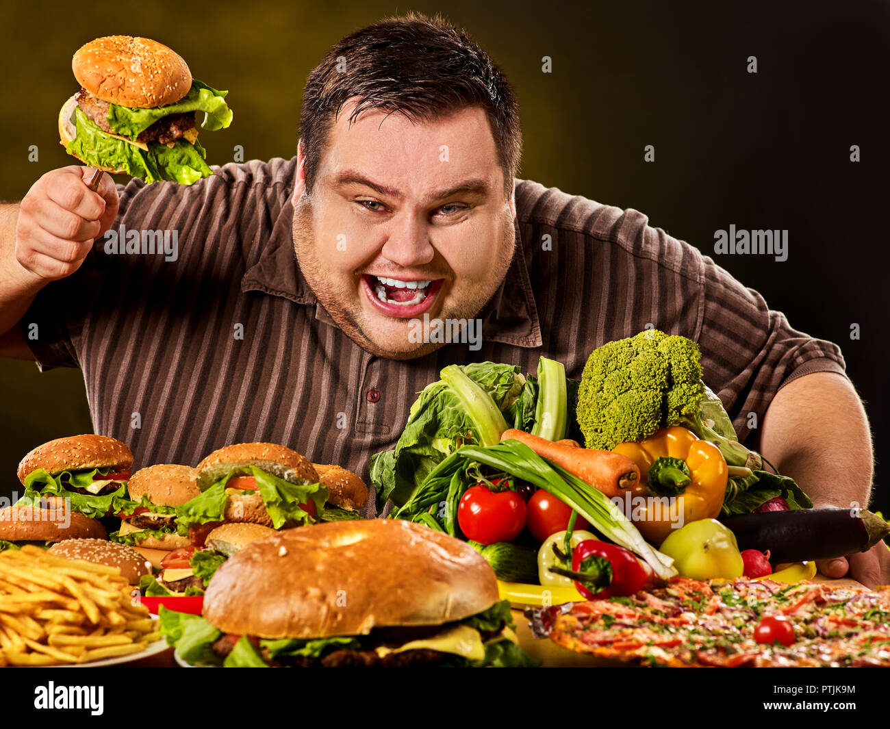 Diet fat man fait de choix entre les aliments sains et malsains. Banque D'Images