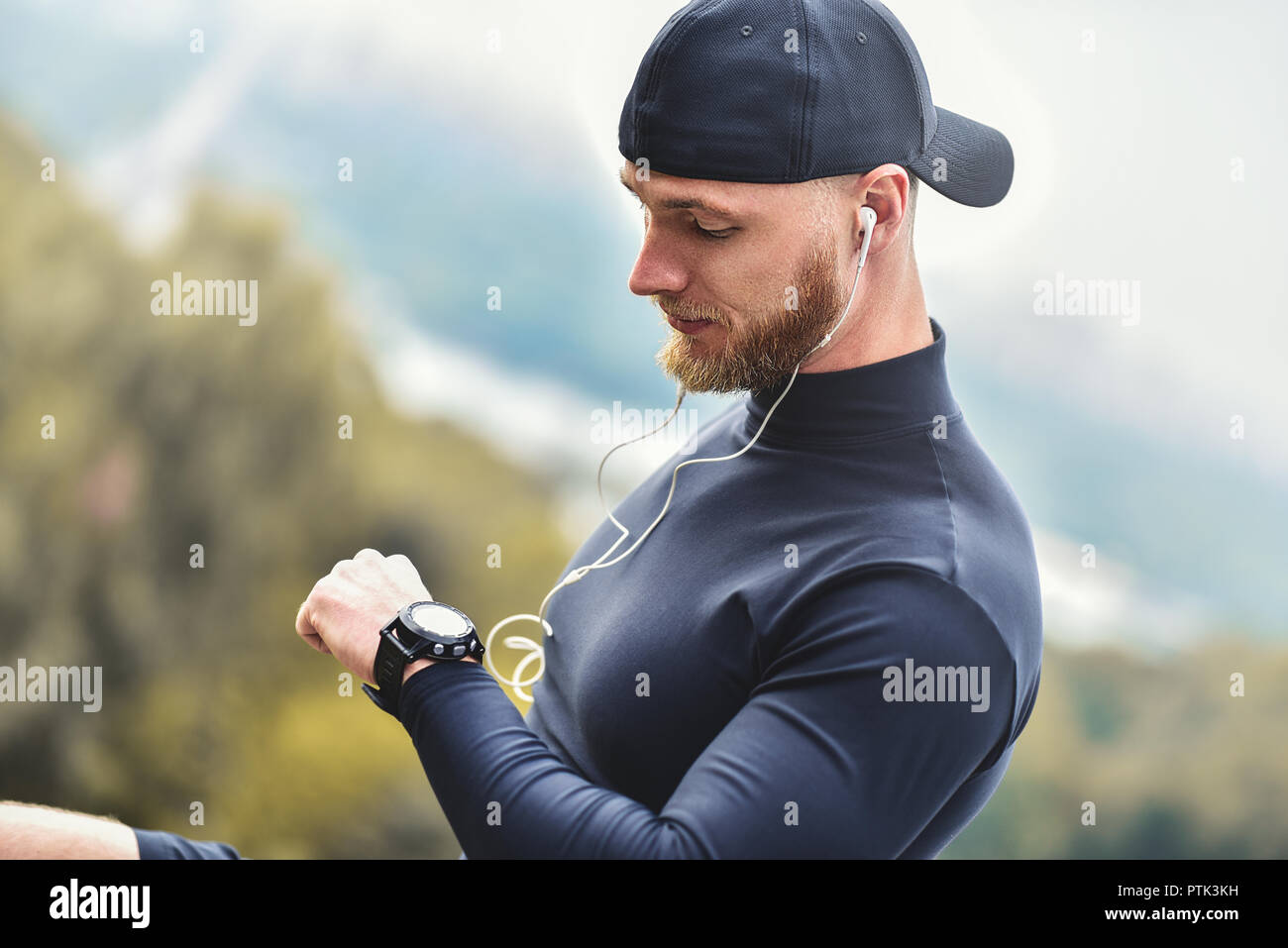 Gros plan homme sportif barbu après Séance d'entraînement de remise en forme des contrôles de résultats. Mec adultes Bracelet Sport Tracker. Banque D'Images