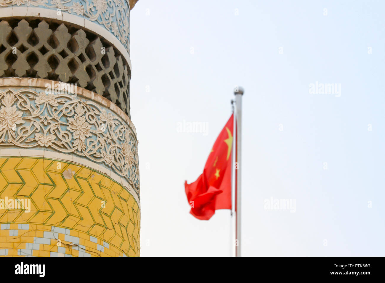 Minaret de la mosquée Uigher Eidgah avec drapeau chinois dans la vieille ville de Kashgar, ou Kashi, Xinjiang, Chine. Banque D'Images