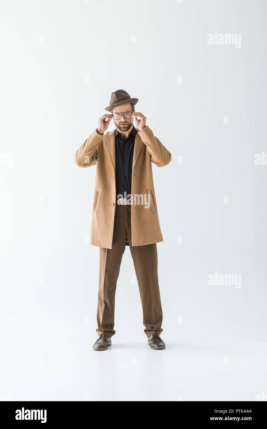 Dans l'homme à la mode manteau marron et un chapeau, isolated on white Banque D'Images