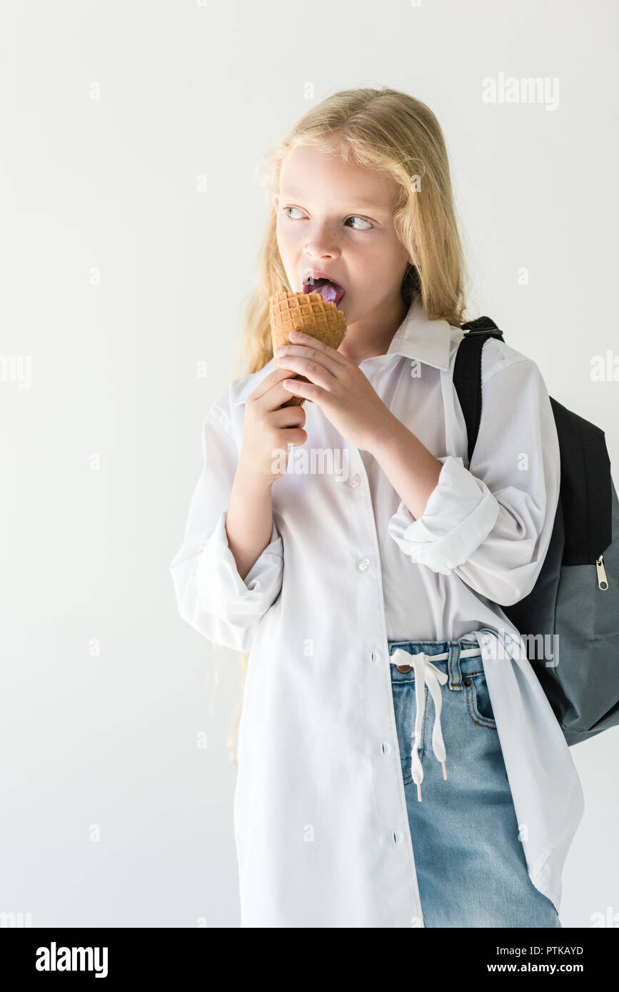 Bel enfant sac à dos avec la consommation de crème glacée et à l'écart isolated on white Banque D'Images