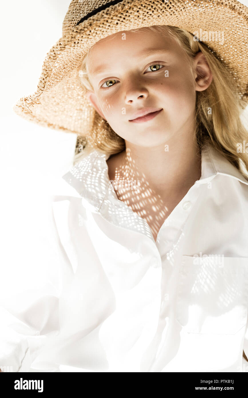 Portrait de l'adorable petit enfant dans l'osier hat smiling at camera on white Banque D'Images