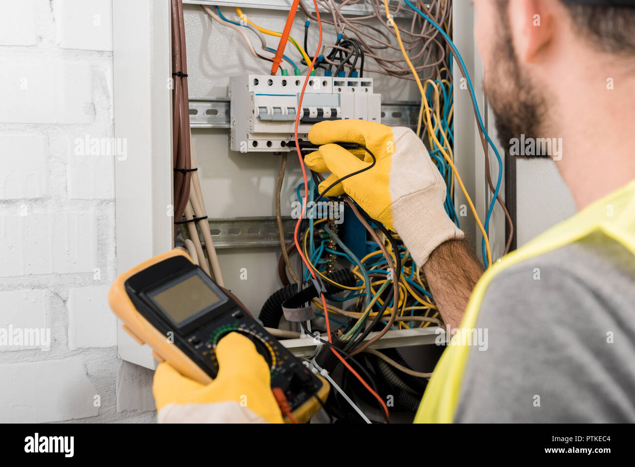 Contrôle de l'électricien de la boîte électrique avec multimetr in corridor Banque D'Images