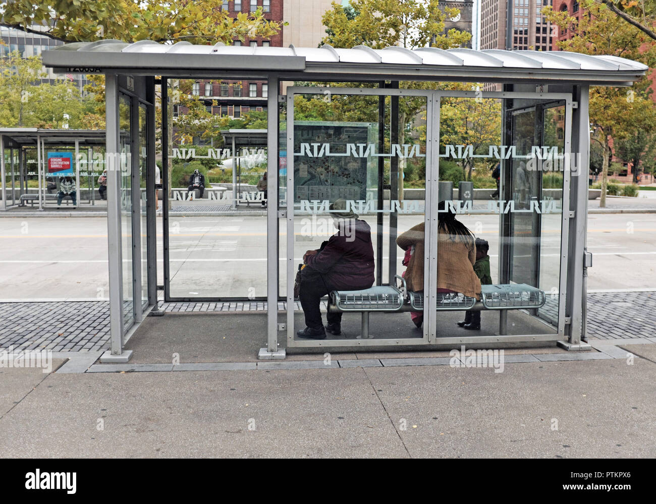 Les femmes attendent dans un abri-bus public sur place publique dans le centre-ville de Cleveland, Ohio, USA. Banque D'Images