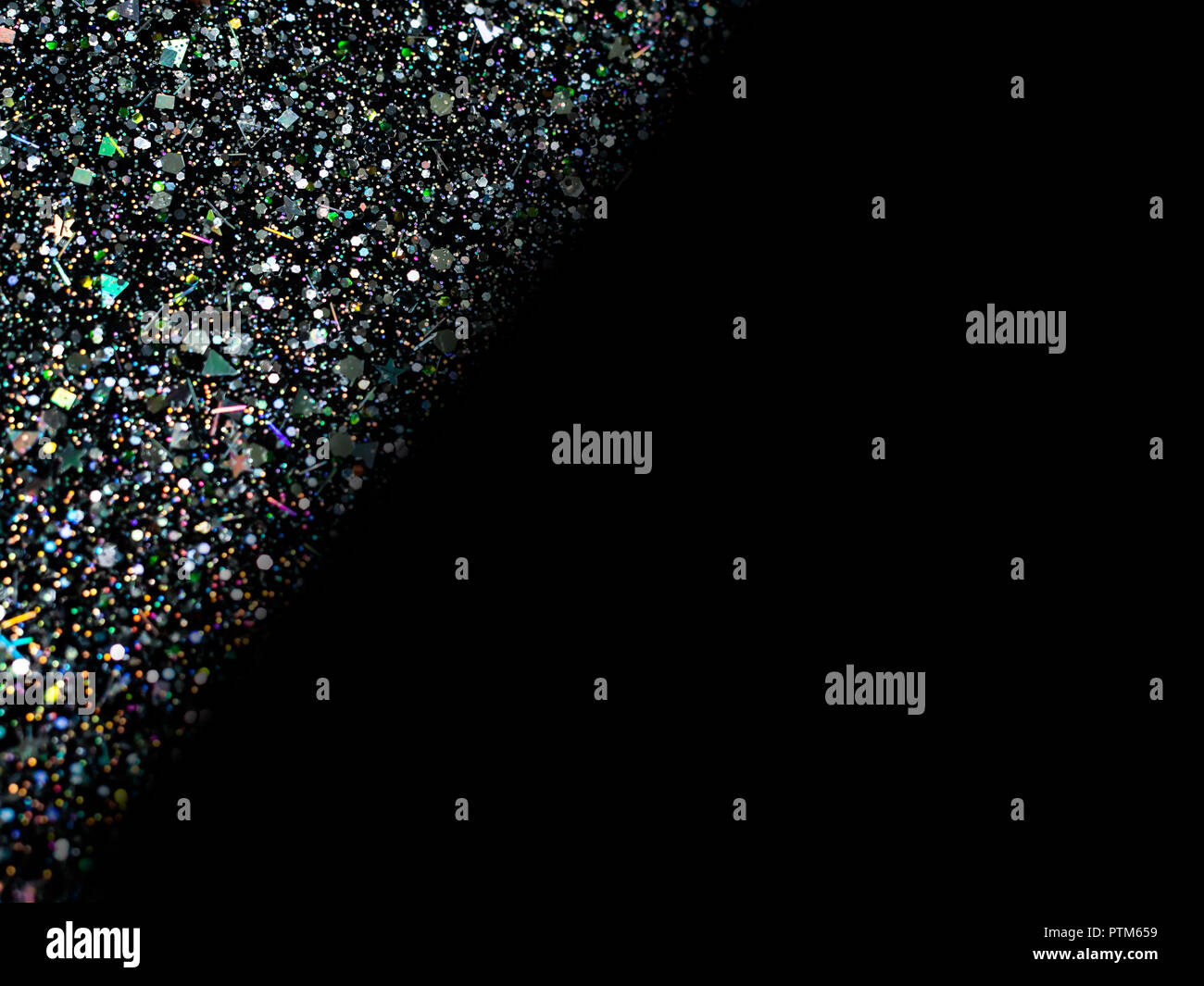 Paillettes holographiques sur fond noir avec l'exemplaire de l'espace. L'art abstrait multicolor glitter. Banque D'Images