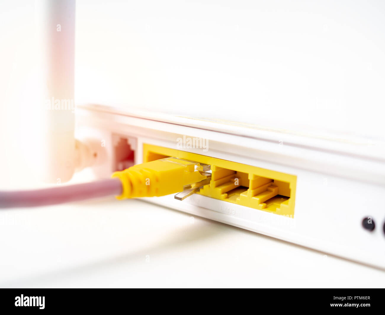 Close-up yellow câble Ethernet connecté sur internet sans fil blanc WIFI  routeur concentrateur du réseau isolé sur fond blanc Photo Stock - Alamy