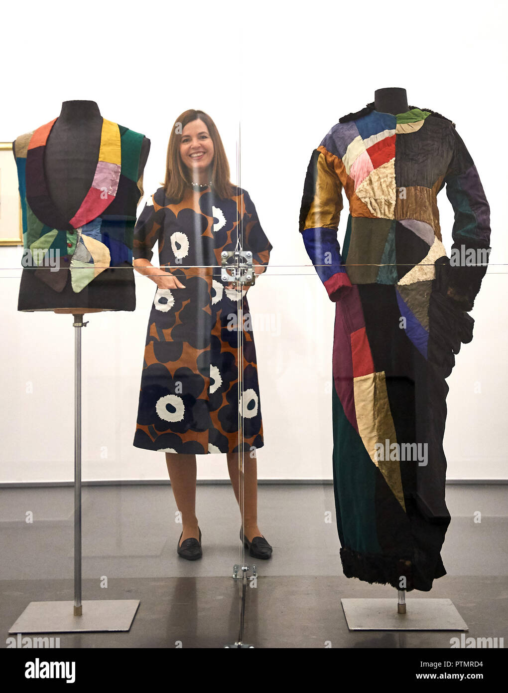 10 octobre 2018, en Rhénanie du Nord-Westphalie, Krefeld : le directeur du Musée, Katia Baudin se tient derrière une vitrine dans le Musée de l'empereur Guillaume dans lequel le soi-disant acquis et simultanée la robe simultanée de l'artiste Sonia Delaunay sont exposées. Dans son exposition 'adaptés à la liberté. La robe de l'artiste autour de 1900 dans la mode, l'Art et société", autour de 300 œuvres de la réforme entre 1900 et 1914. Le spectacle dure du 12 octobre au 24 février 2019. Photo : Bernd Thissen/dpa Banque D'Images