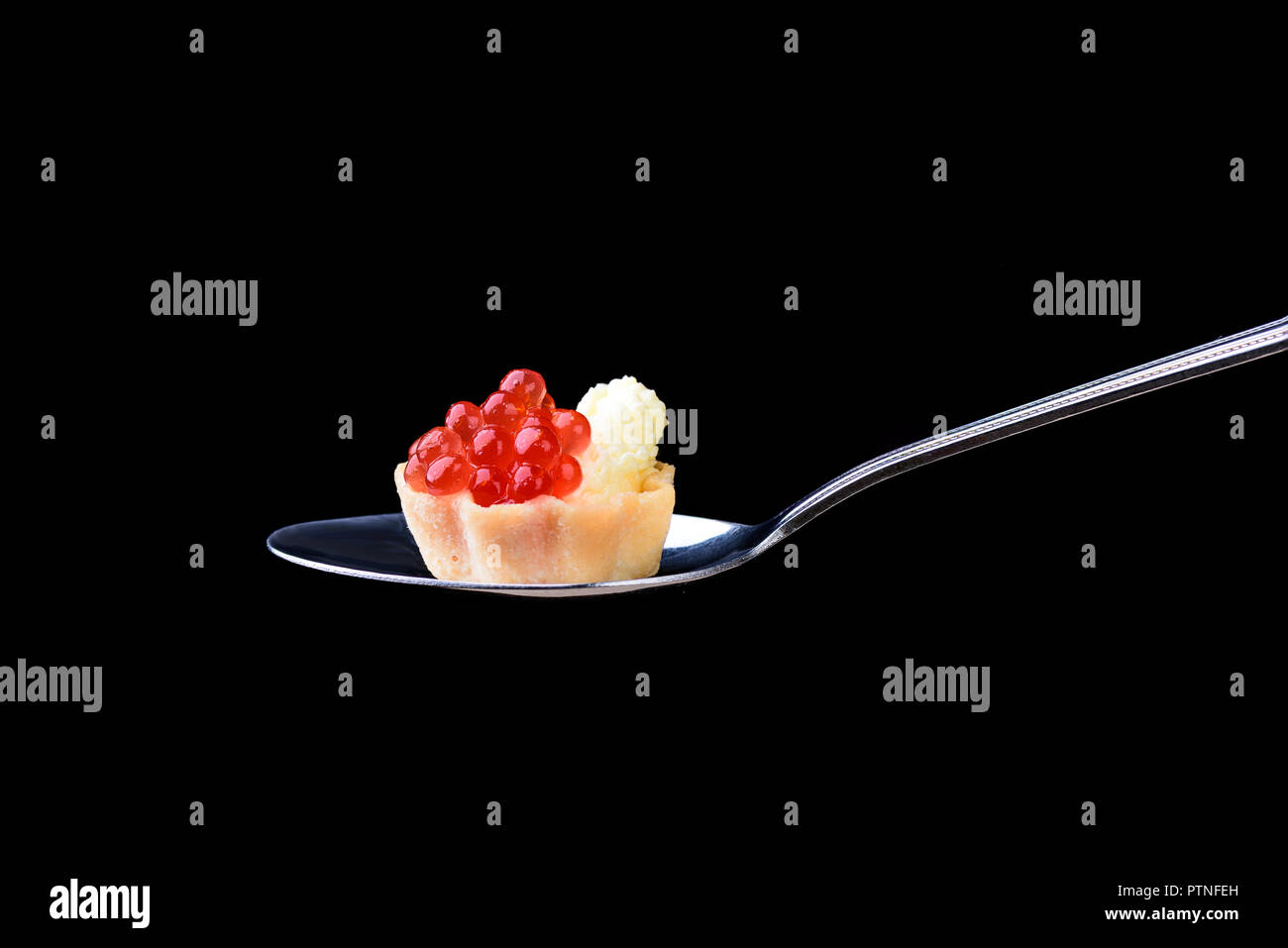 Avec tartelette au caviar rouge et le beurre sur une cuillère à soupe noire sur une ba Banque D'Images