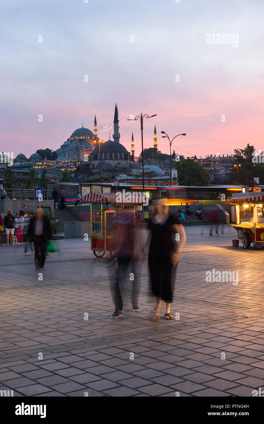 Bazar d'Eminonu avec des stands de nourriture et les gens avec la mosquée Suleymaniye allume à l'arrière-plan au coucher du soleil, Istanbul, Turquie Banque D'Images