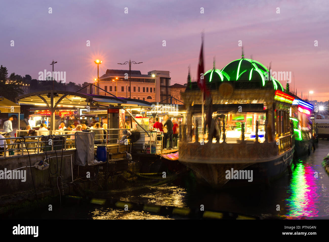 La cuisine flottante de bazar d'Eminonu allumé jusqu'au crépuscule avec des gens assis dans la salle à manger, Istanbul, Turquie Banque D'Images