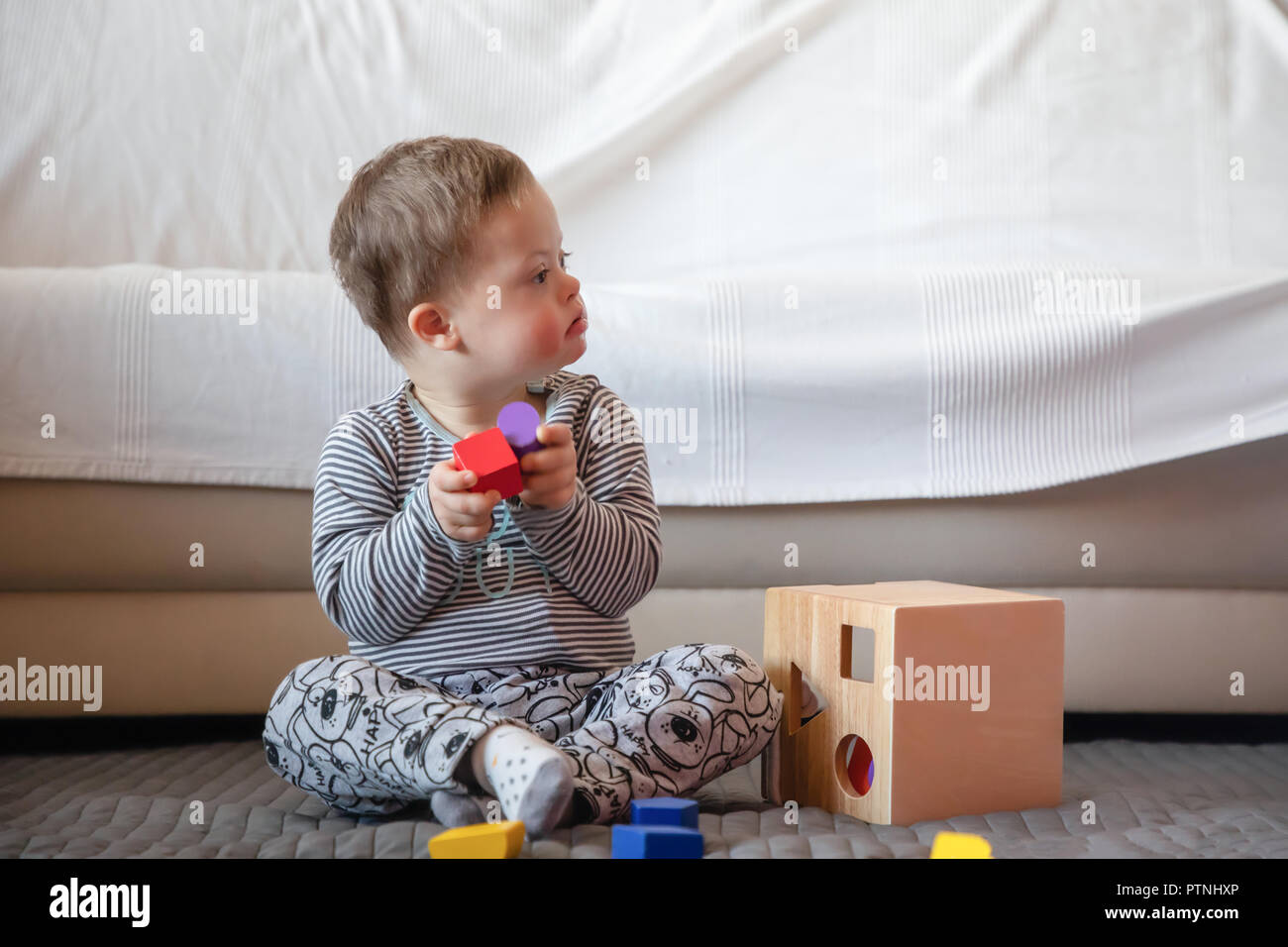 Portrait of cute boy avec le syndrome de jouer dans la maison Banque D'Images