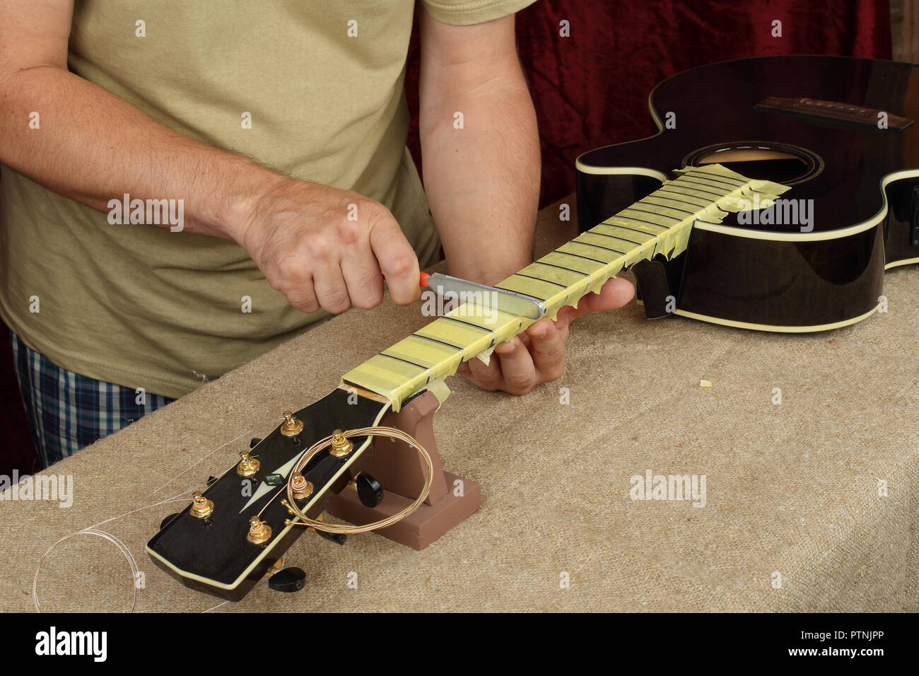 Réparation guitare instrument de musique et le service d'affûtage -  Travailleur de l'outil bridge l'écrou de l'amplificateur de guitare  acoustique noir Photo Stock - Alamy