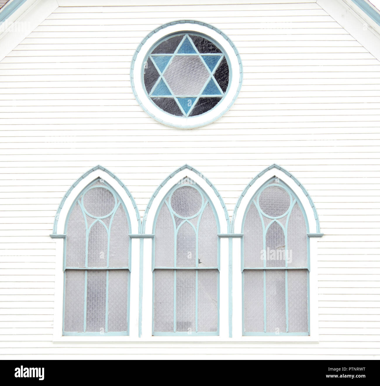 Un vitrail Etoile de David (Maguen David) (David Mogen) se détache sur le côté d'une église de 100 ans. Banque D'Images