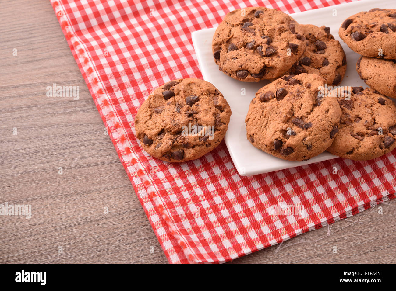 Petit-déjeuner avec des biscuits dans un plat avec des pépites de chocolat noir sur la nappe et en bois table de cuisine. Top View. Composition horizontale Banque D'Images