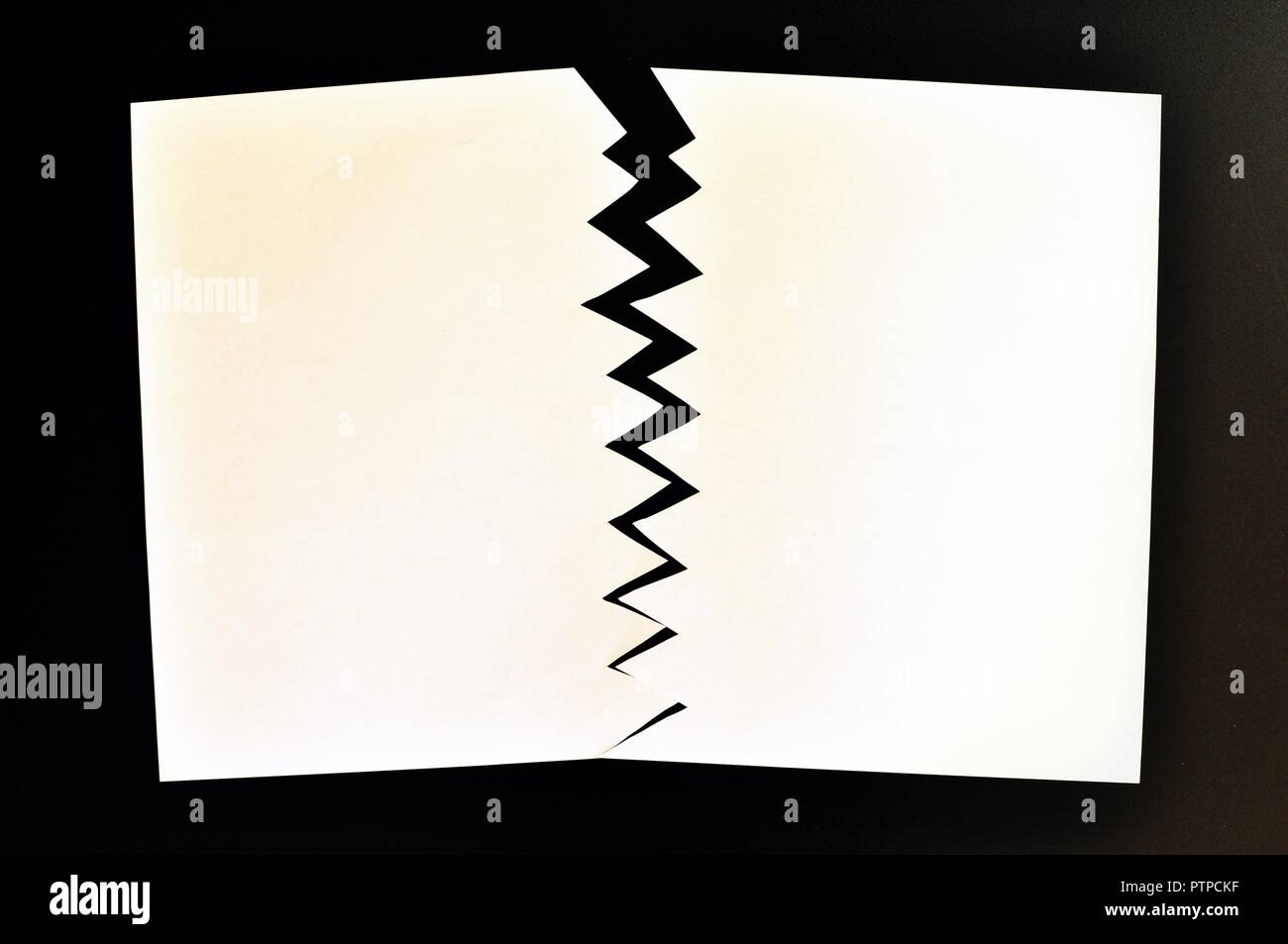 Concept de divisé ou séparé en deux feuilles de papier déchiré. Papier blanc déchiré dans la moitié isolé sur fond noir. Vue d'en haut Banque D'Images