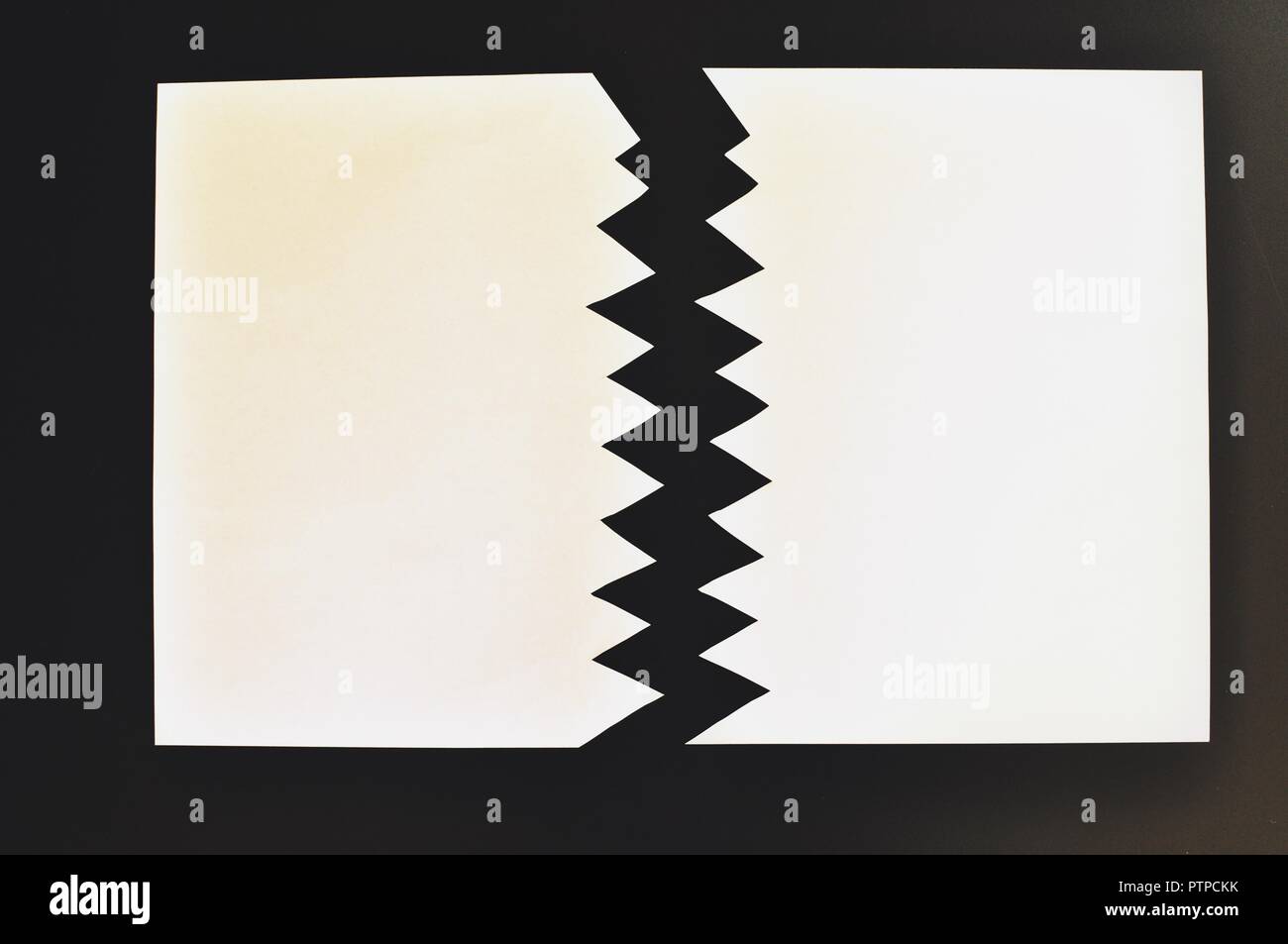 Concept de symbolique divisé ou séparé en deux feuilles de papier déchiré. Papier blanc déchiré dans la moitié isolé sur fond noir. Vue d'en haut Banque D'Images