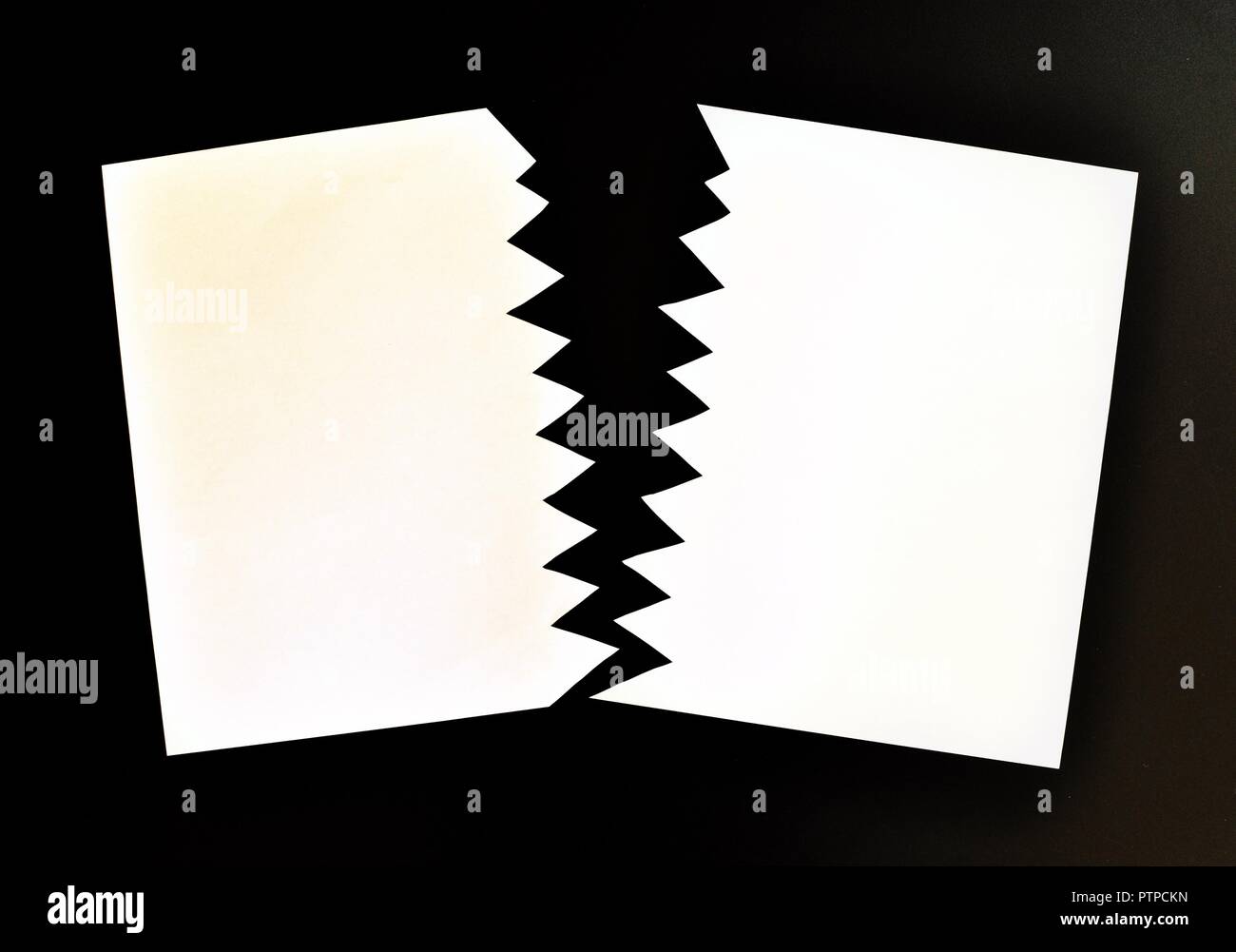 Concept de divisé ou séparé en deux feuilles de papier déchiré. Papier blanc déchiré dans la moitié isolé sur fond noir. Vue d'en haut Banque D'Images