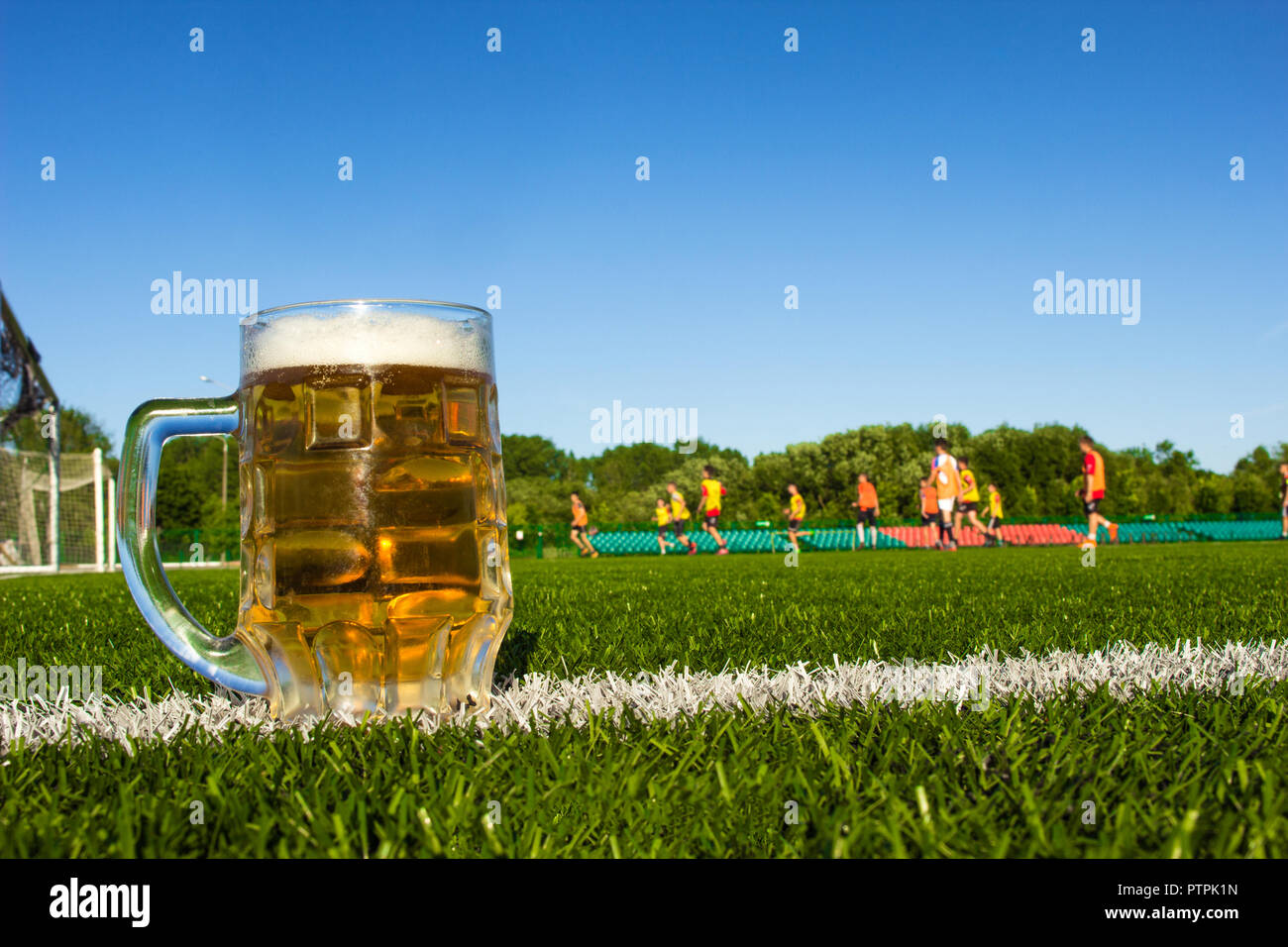 Un verre de bière est sur un terrain de football, le football est joué dans le stade Banque D'Images