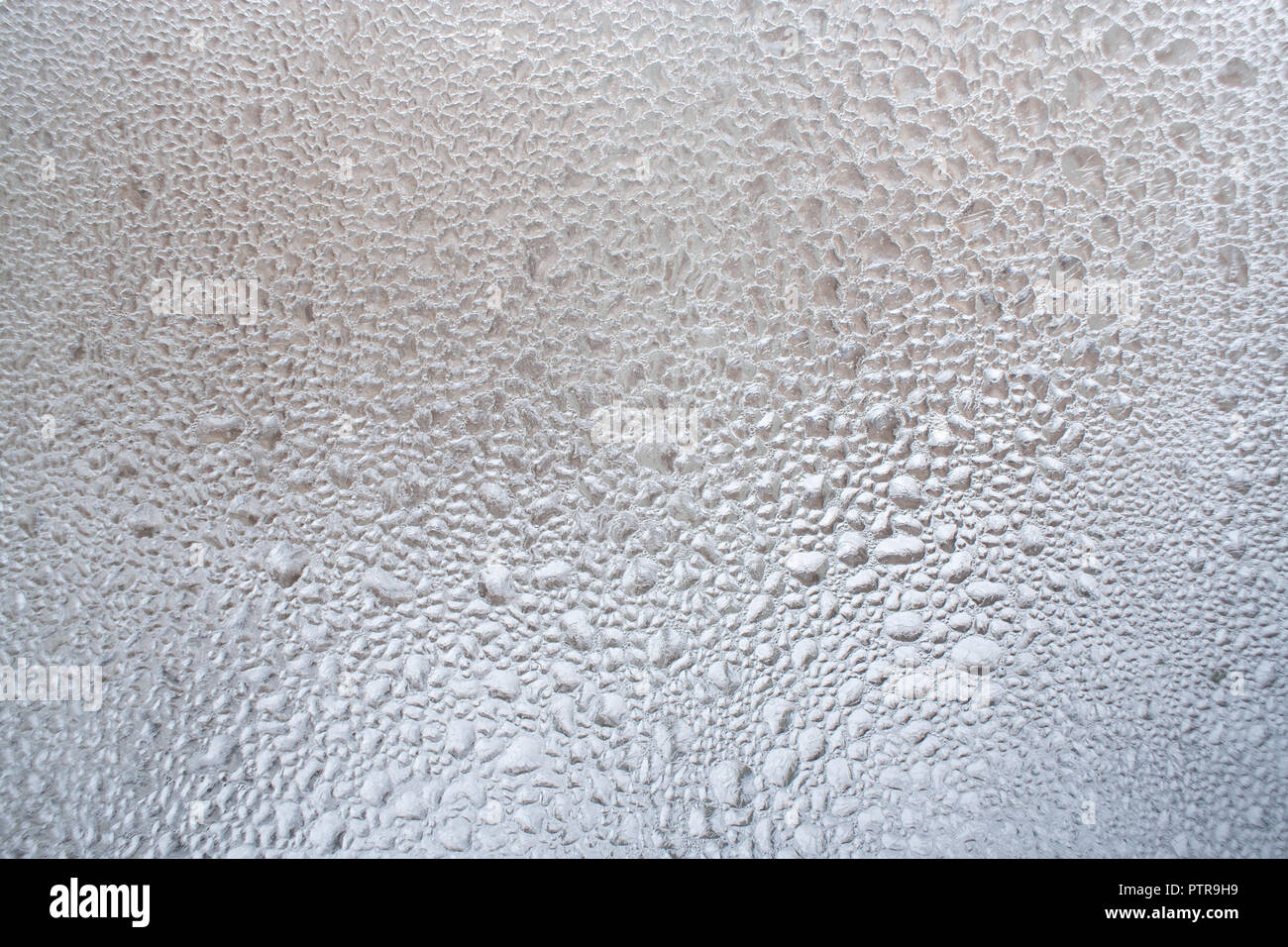 Grande concentration de gouttelettes d'eau sur la fenêtre d'hiver comme arrière-plan. Banque D'Images