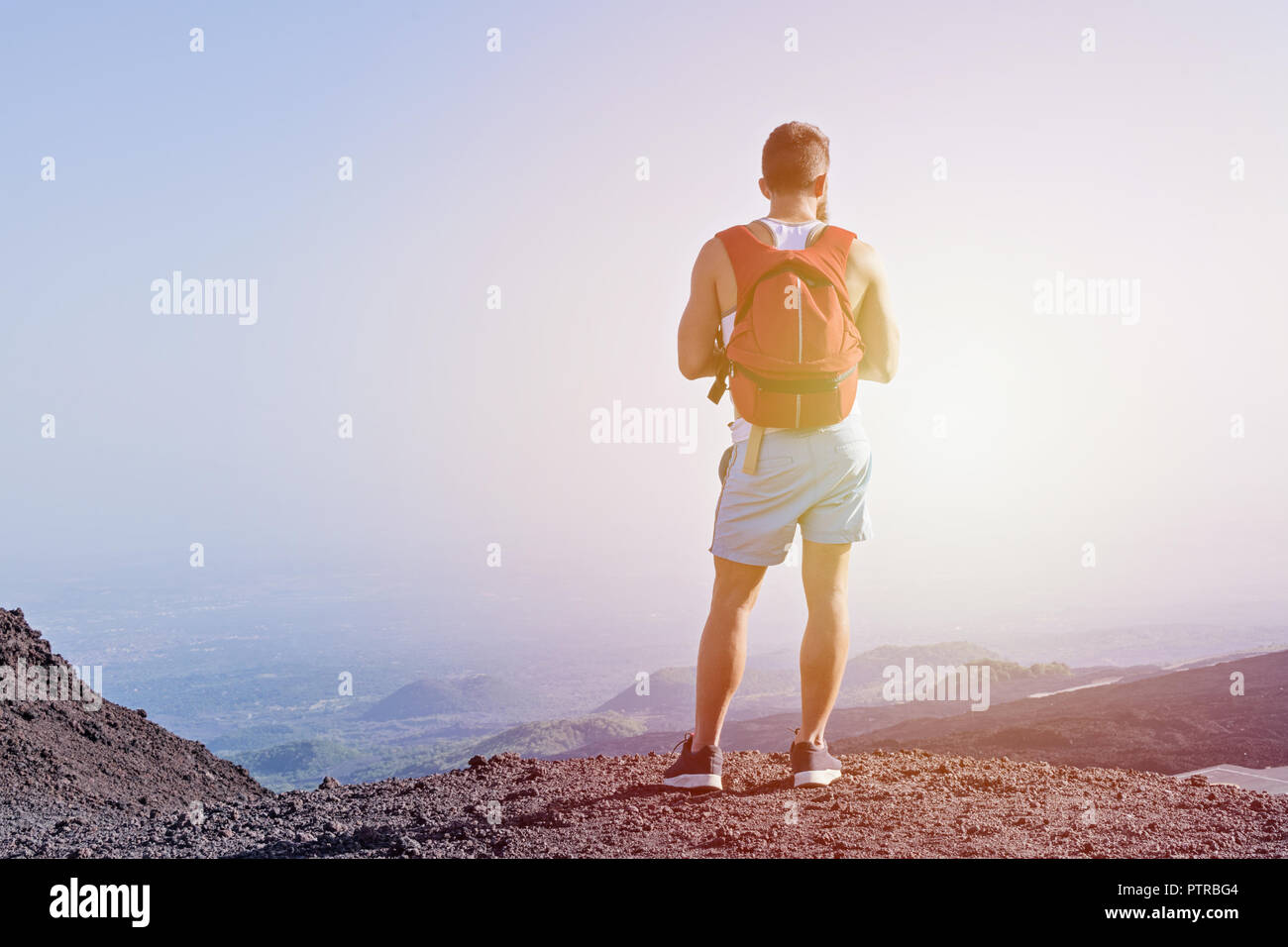Vue de la jeune homme debout derrière a grimpé jusqu'à la montagne et profiter des belles vues de la nature. Concept de la randonnée en terrain accidenté et guérir Banque D'Images