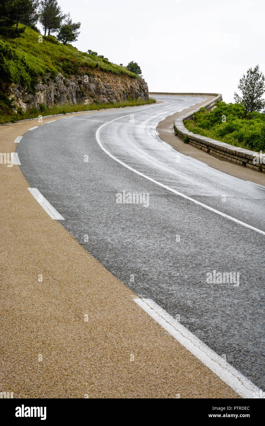 Route de montagne humide avec parapet de pierre montagne sinueuse dans le sud de la France un jour de pluie. Banque D'Images