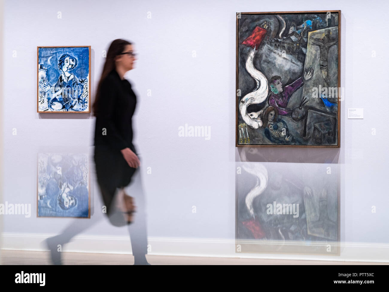 10 octobre 2018, en Rhénanie du Nord-Westphalie, Muenster : 10 octobre 2018, l'Allemagne, Münster : une femme marche à travers l'exposition de Marc Chagall "LE RÊVEUR éveillé" au musée Pablo Picasso. Autour de 120 œuvres de Marc Chagall peut être vu à partir de ce samedi sur dans l'exposition 'Der wache Traeumer' à Muenster. Au Musée d'Art de Pablo Picasso, les visiteurs peuvent s'immerger dans l'artiste rêve fantastique 'WORLD', le musée a annoncé, lors d'une présentation préliminaire le mercredi. Parmi les peintures, dessins en couleur et éléments graphiques en couleur sont aussi prêts de la célèbre Centre Pompidou à Paris ou ra Banque D'Images