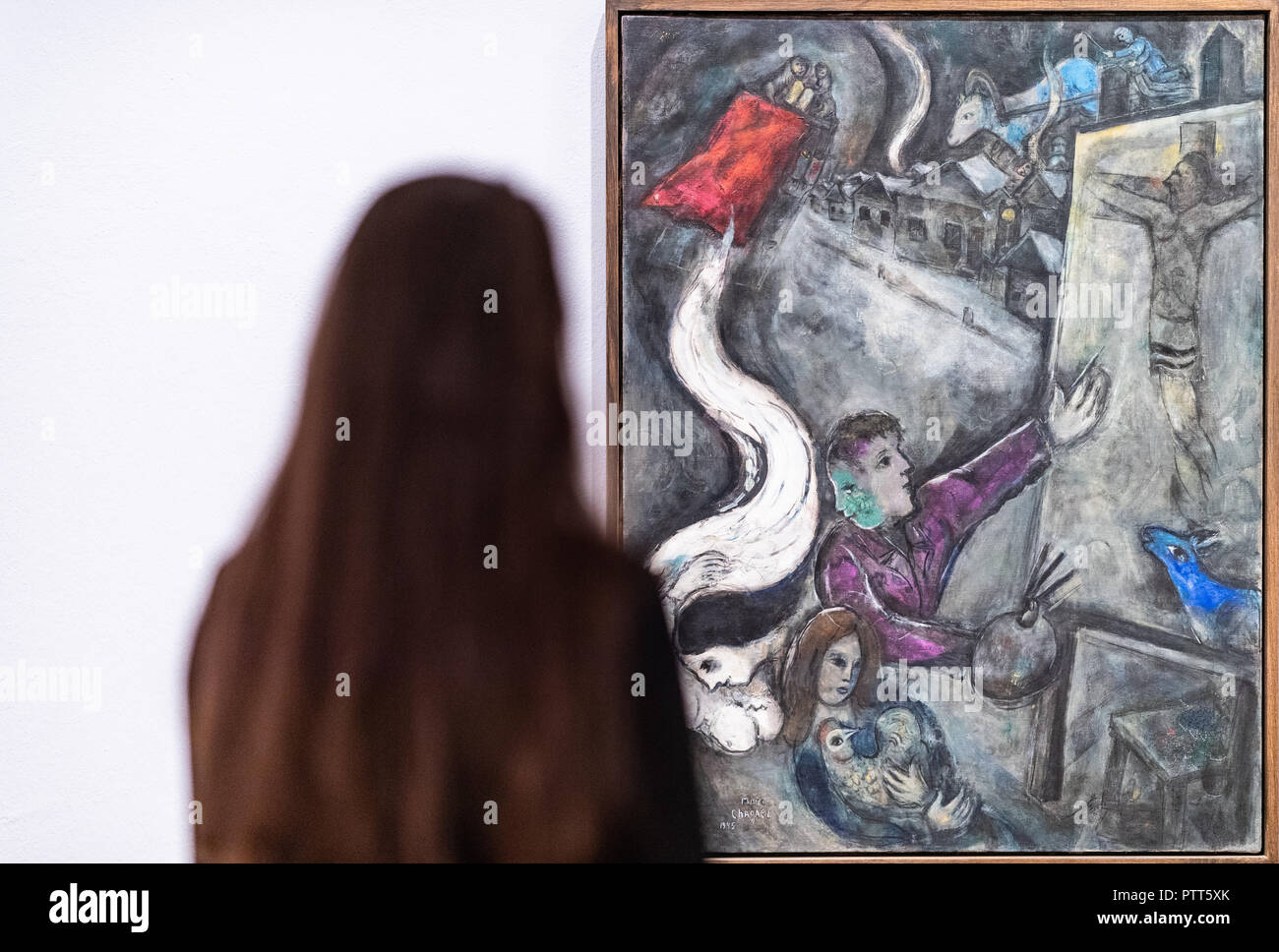 10 octobre 2018, en Rhénanie du Nord-Westphalie, Muenster : 10 octobre 2018, l'Allemagne, Münster : une femme dans le musée Pablo Picasso se trouve en face d'une peinture de Marc Chagall "l'âme de la ville". Autour de 120 œuvres de Marc Chagall peut être vu à partir de ce samedi sur dans l'exposition 'Der wache Träumer" à Muenster. Au Musée d'Art de Pablo Picasso, les visiteurs peuvent s'immerger dans l'artiste rêve fantastique 'WORLD', le musée a annoncé, lors d'une présentation préliminaire le mercredi. Parmi les peintures, dessins en couleur et éléments graphiques en couleur sont aussi prêts de la célèbre Centre Pompidou à par Banque D'Images