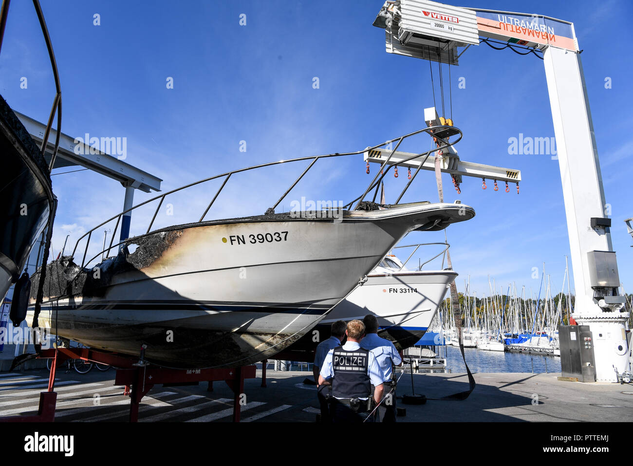 11 octobre 2018, Bade-Wurtemberg, Kressbronn : policiers regardent plusieurs yachts à moteur qui a brûlé et ont été amenés à terre. Photo : Felix Kästle/dpa Banque D'Images