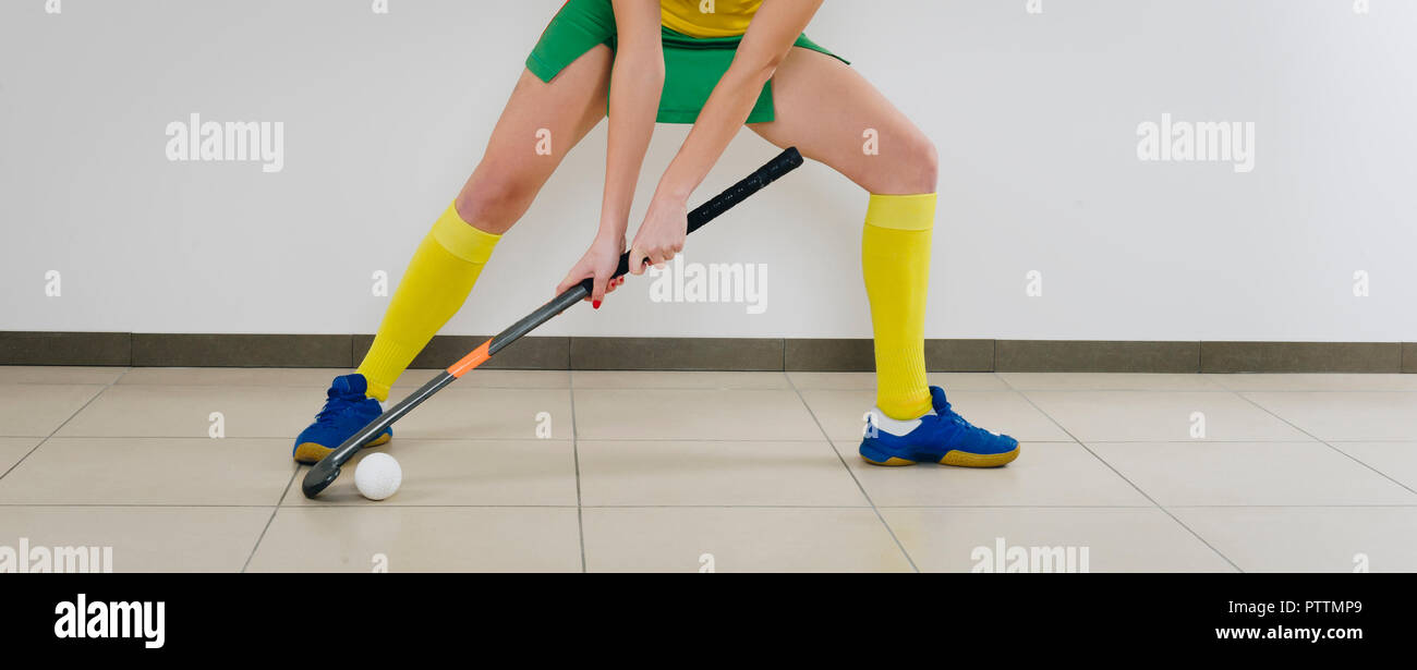 Belle Jeune femme tenant le bâton de hockey et de balle contre fond blanc Banque D'Images