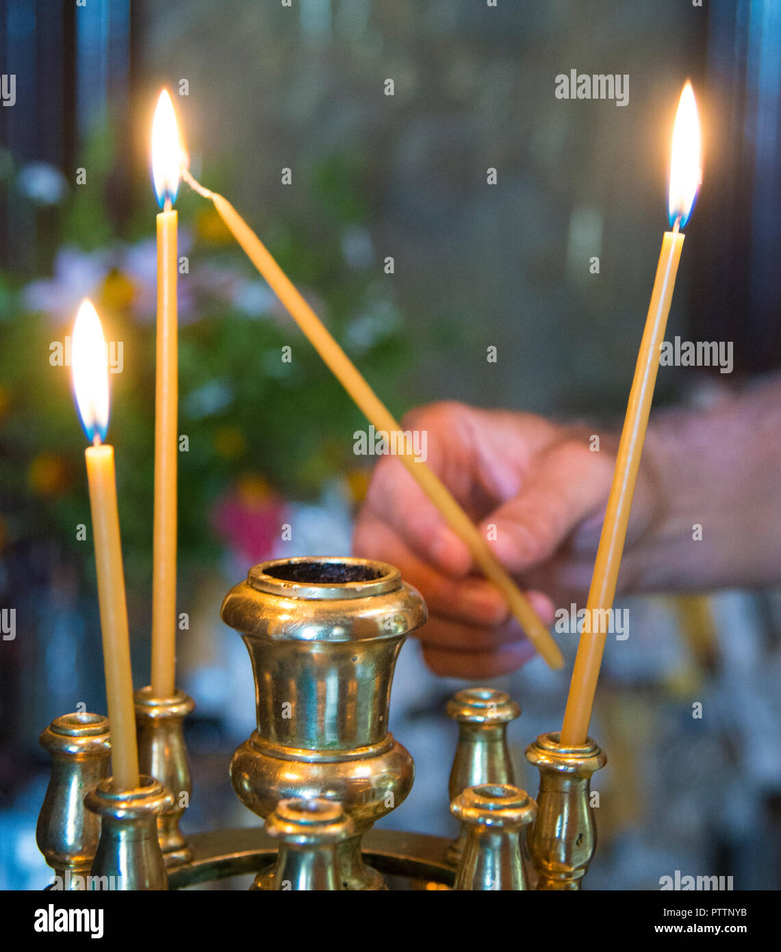Prière d'éclairage d'une bougie à l'intérieur de l'église Grecque Banque D'Images