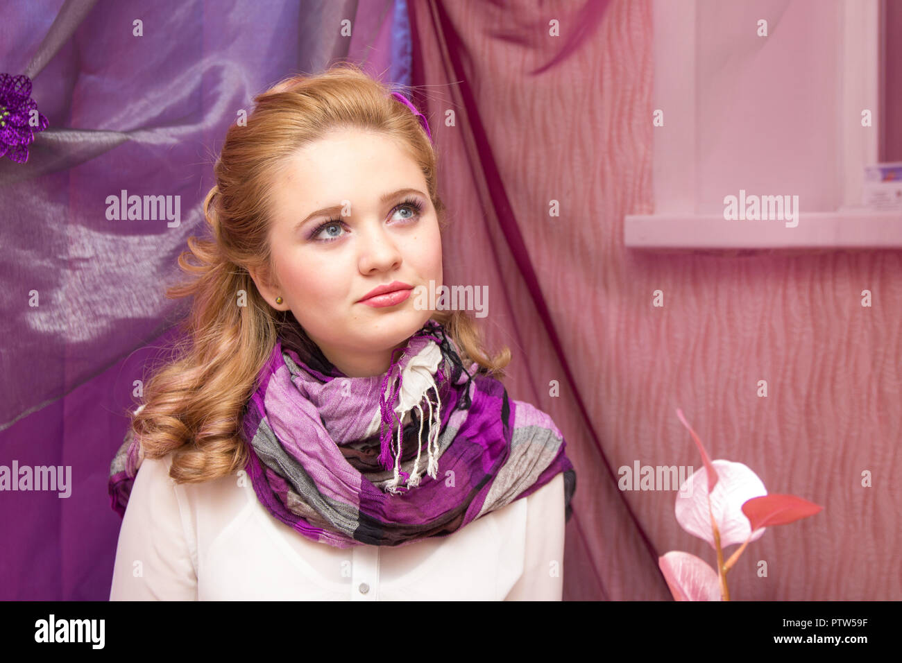 Une jeune fille blonde dans un foulard mauve à l'appareil photo Banque D'Images