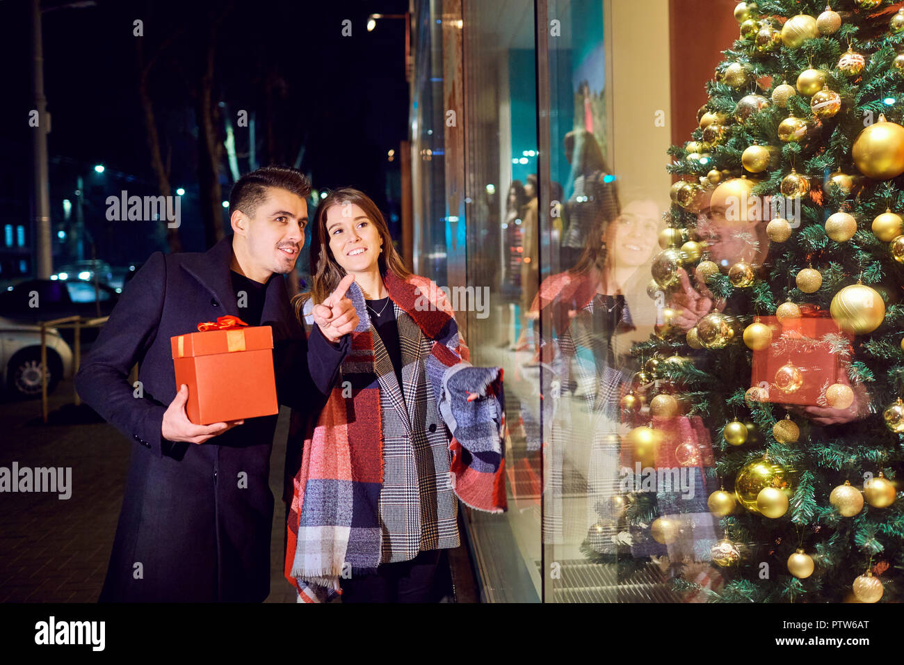 Un jeune couple avec des paquets est shopping le jour de Noël. Banque D'Images