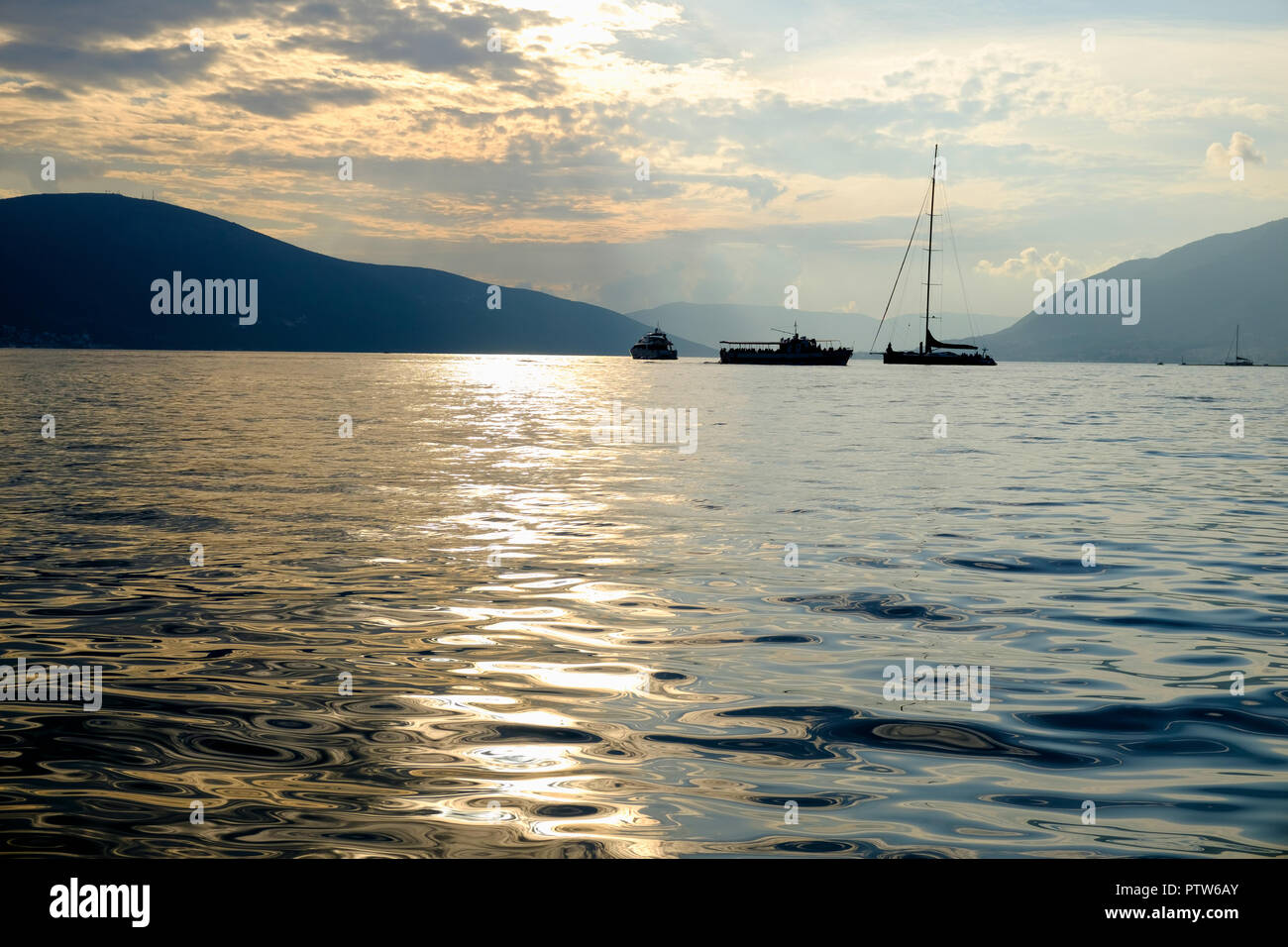 Voilier, Bateau de tourisme dans la mer dans la soirée du soleil sur de belles grandes montagnes, l'arrière-plan d'aventure estivale de luxe, vacances actives dans Milan, Banque D'Images