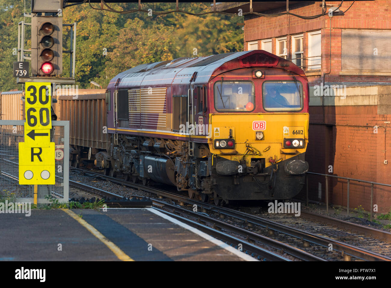 Limitation de vitesse temporaire de panneaux et d'un train de marchandises de la classe 66 exploité par serveur Web intégré à la gare de Southampton le transport de granulats de wagons. Banque D'Images