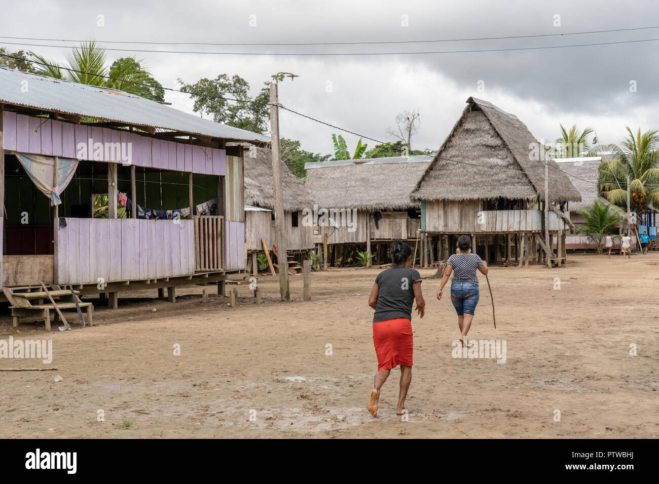 Puerto Miguel Pérou, Amérique du Sud. Les autochtones marchant à côté leurs maisons sur pilotis du village de Puerto Miguel. (Pour un usage éditorial uniquement) Banque D'Images