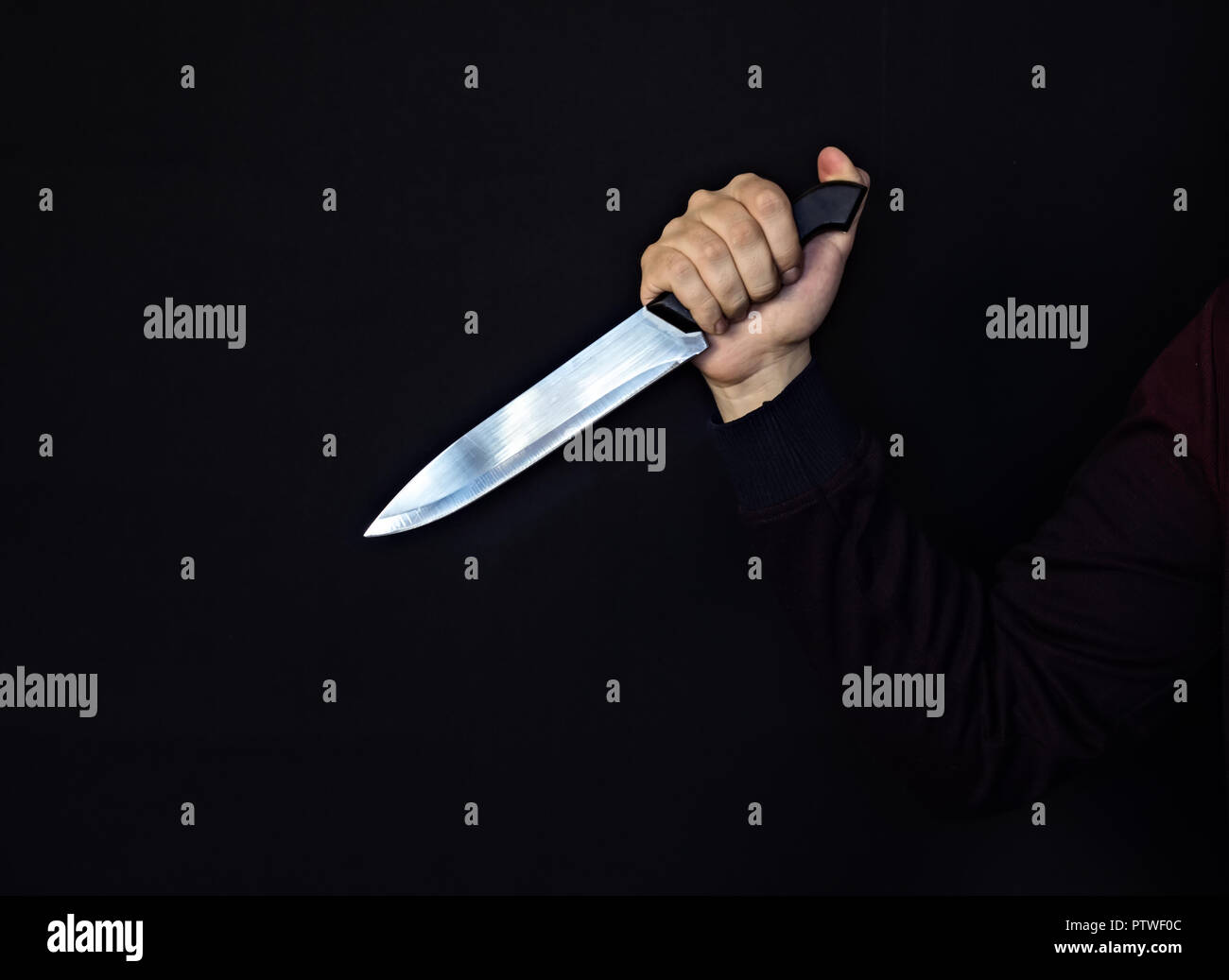 La main de l'homme avec un couteau, fond noir, close-up, danger Banque D'Images