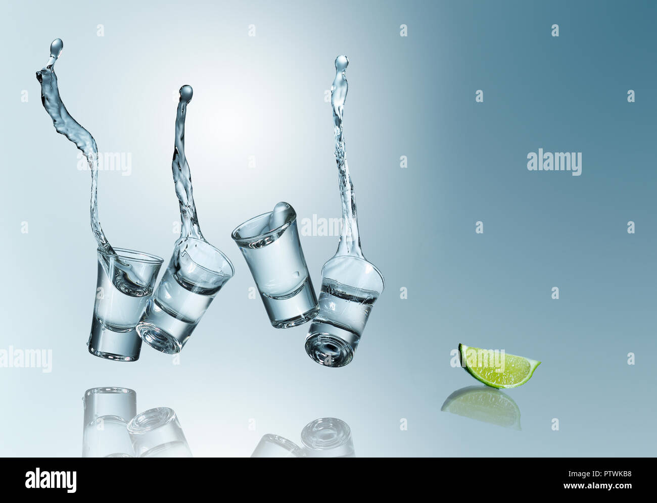 Tequila déversant dans des verres avec lime, studio shot Banque D'Images