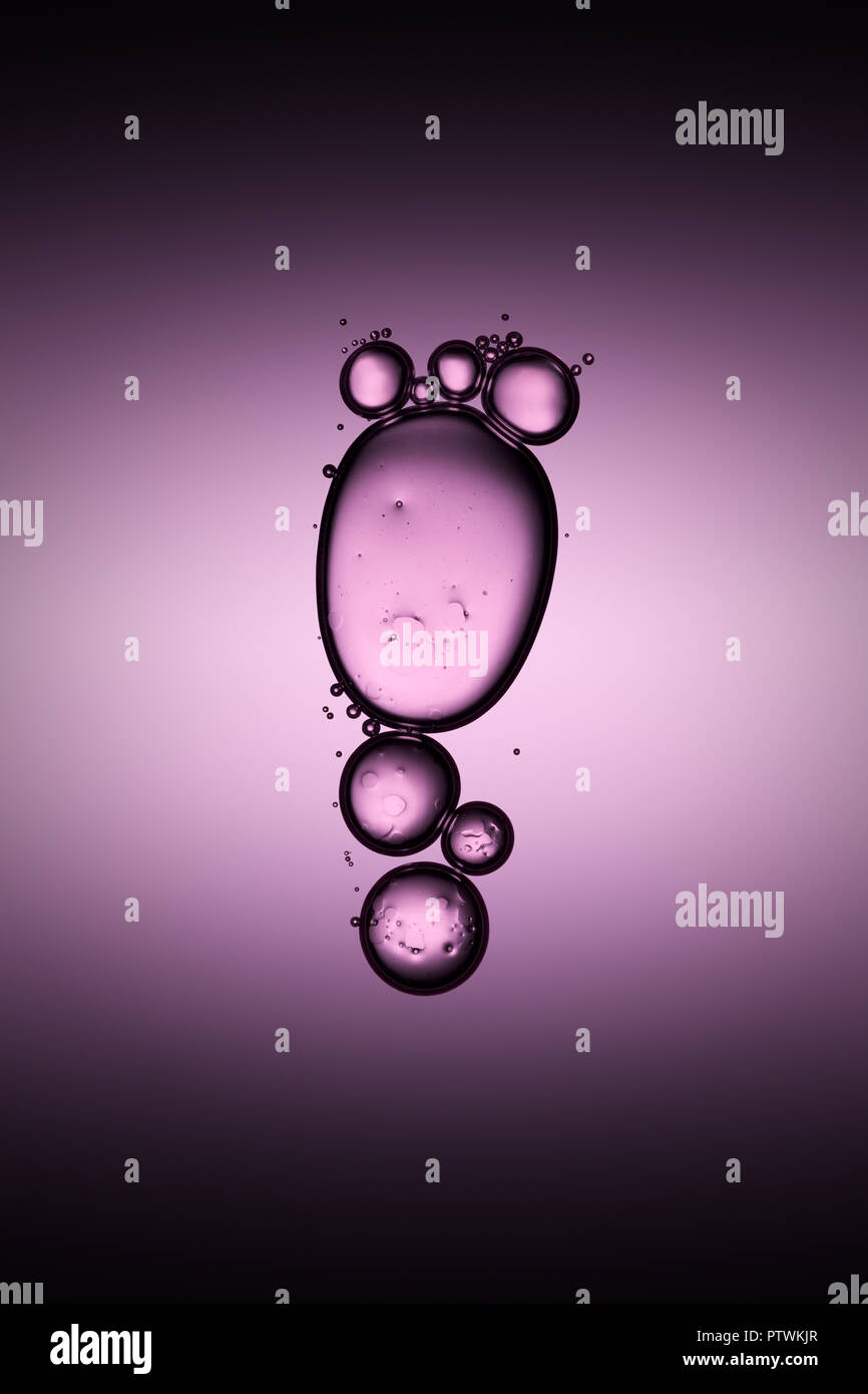 Bulles transparentes flottant dans un liquide, fond violet Banque D'Images