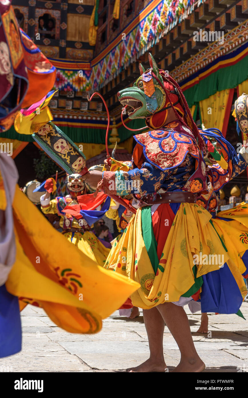 Le moine bouddhiste de la danse et la tenue d'un tambour de danse de masque coloré à Paro Tsechu festival annuel le bouddhisme au Bhoutan temple monastère emplacement. Banque D'Images