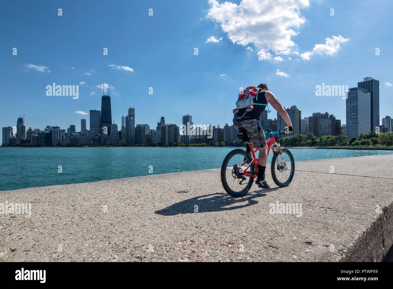 Cycliste sur le quai de North Avenue Beach, ligne d'horizon à l'arrière, Chicago, Illinois, États-Unis Banque D'Images