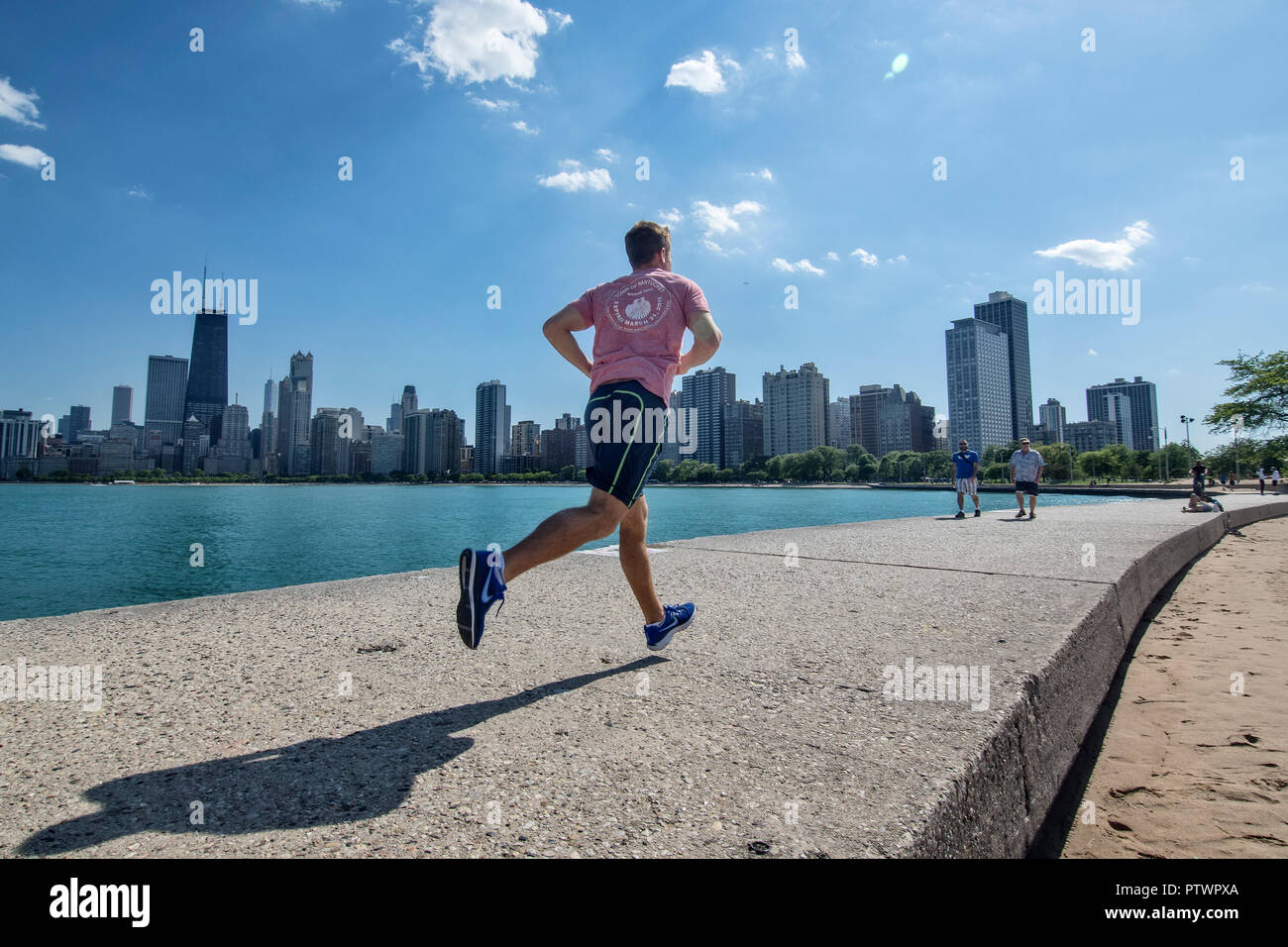 Jogger sur le quai de North Avenue Beach, ligne d'horizon à l'arrière, Chicago, Illinois, États-Unis Banque D'Images