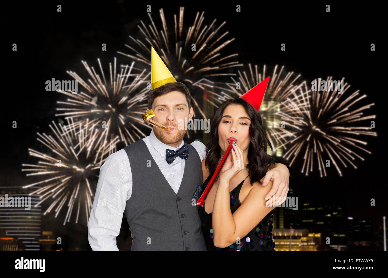 Couple heureux avec party blowers s'amusant Banque D'Images